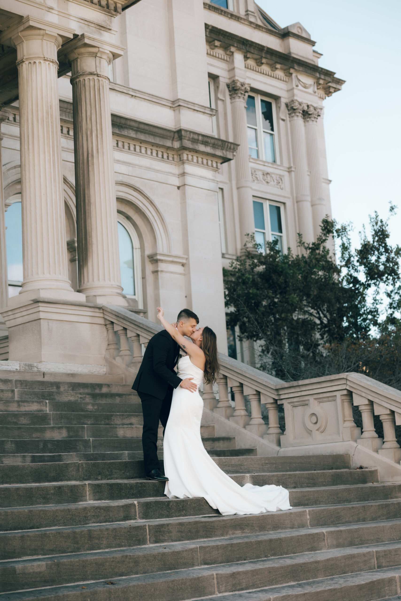 Wedding Couple kissing in front of courhouse