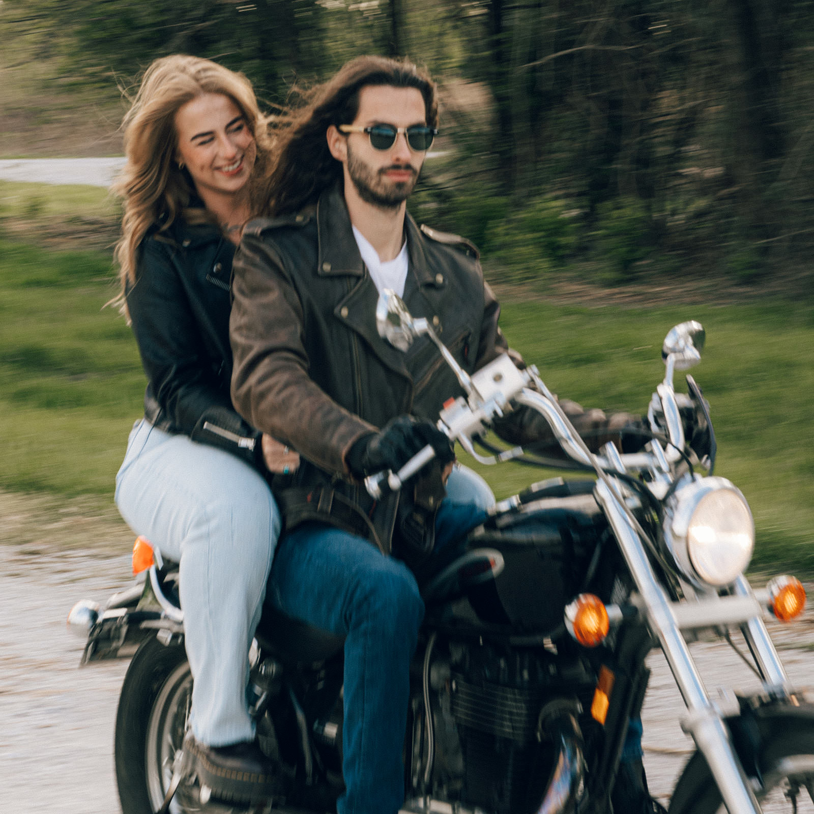 Couple riding on a retro motorcycle in the springtime