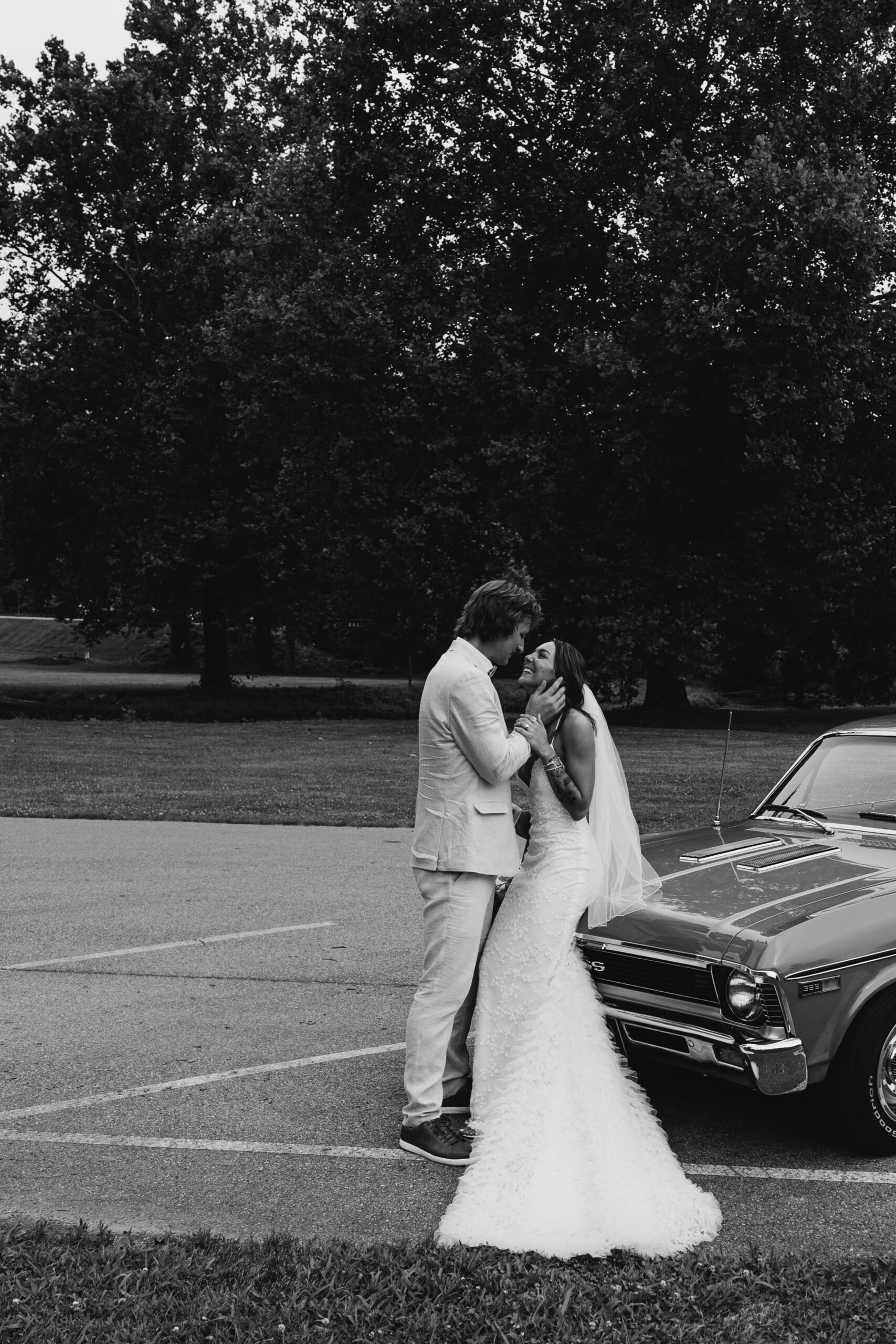 Couple cuddling in front of retro car