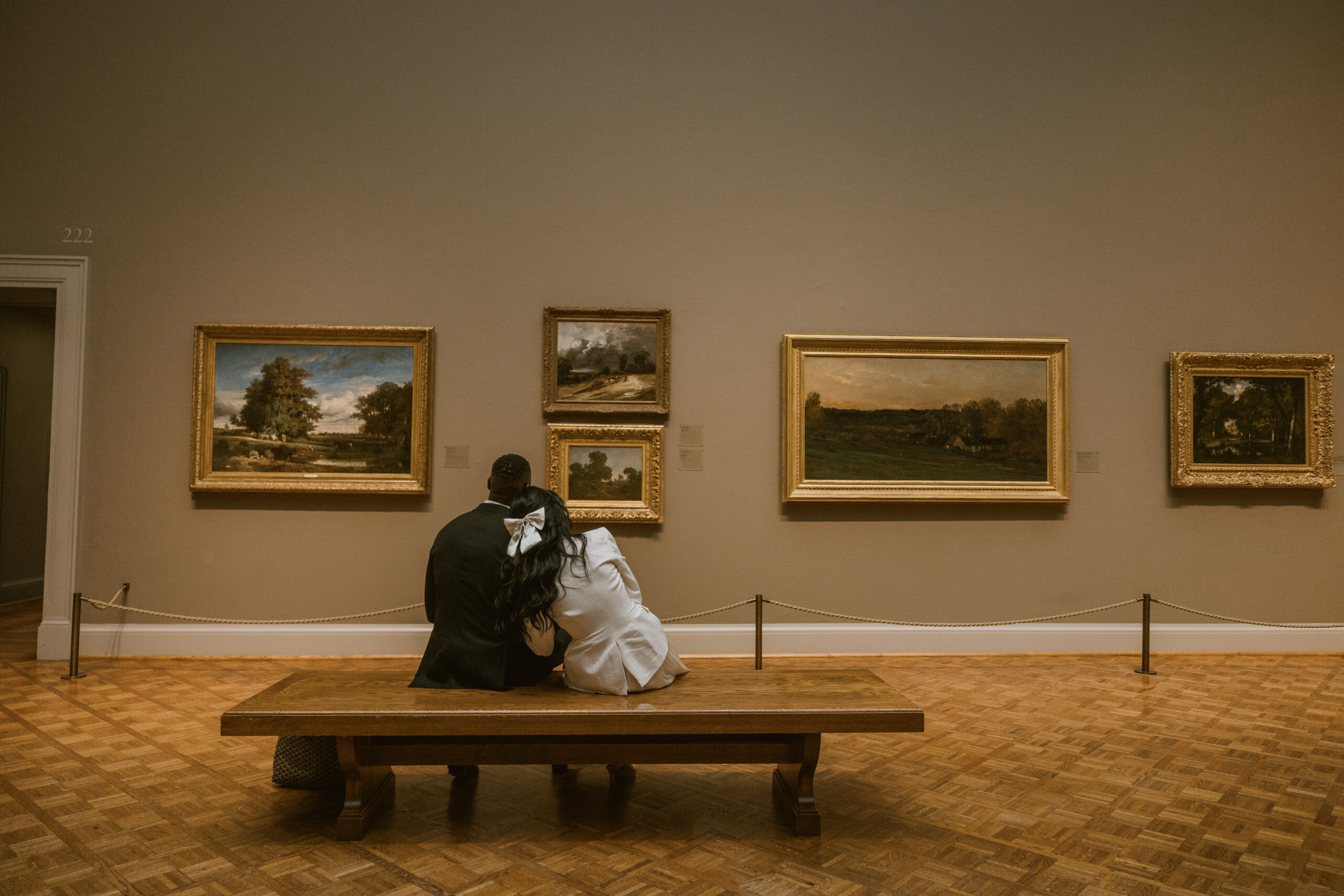 couple cuddling on the bench while admiring art